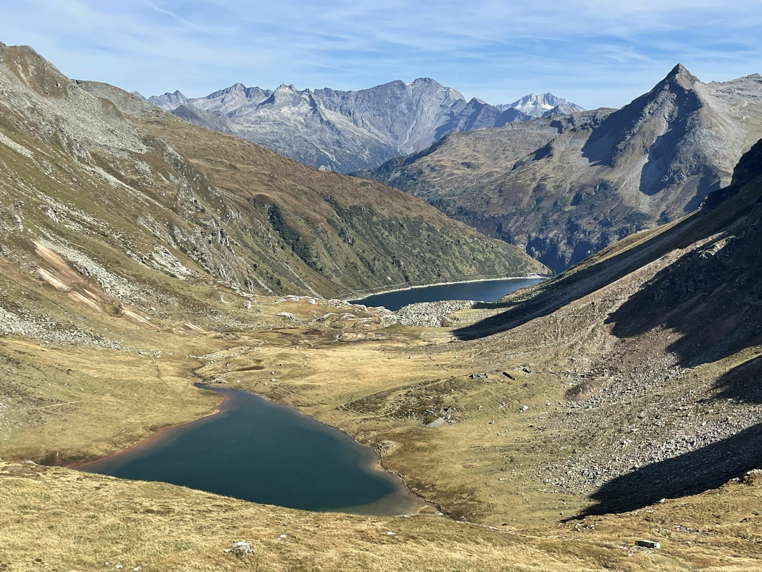 Weites Hochgebirgspanorama mit zwei Seen im Tal und kargen Berghängen unter blauem Himmel. – Gasteinertal